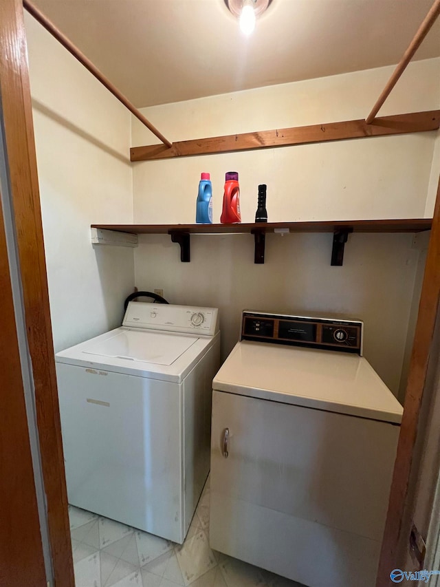 laundry room with light tile patterned flooring and washer and clothes dryer