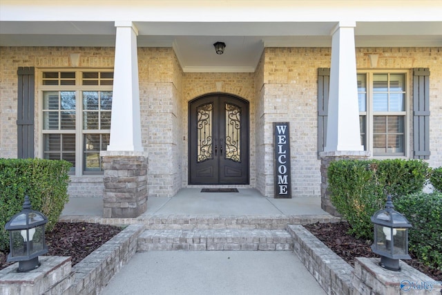 entrance to property with a porch and french doors