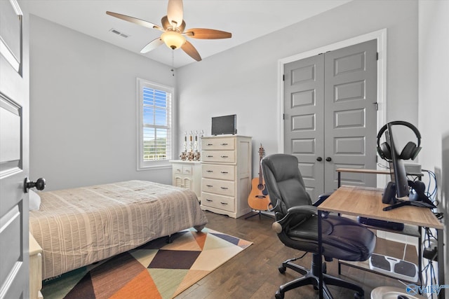 bedroom featuring ceiling fan, dark hardwood / wood-style flooring, and a closet