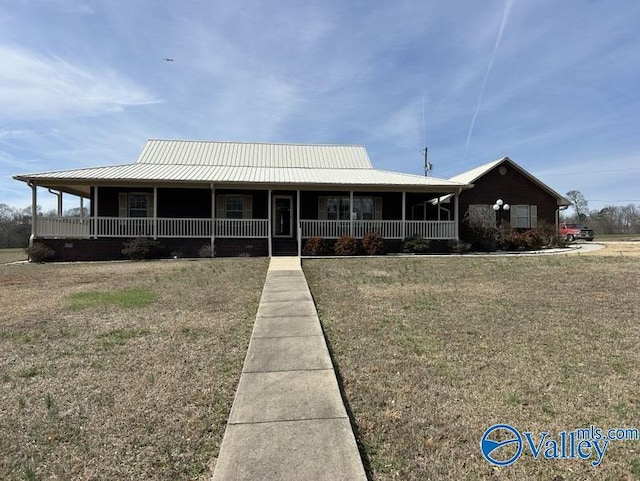 farmhouse-style home featuring covered porch and a front yard