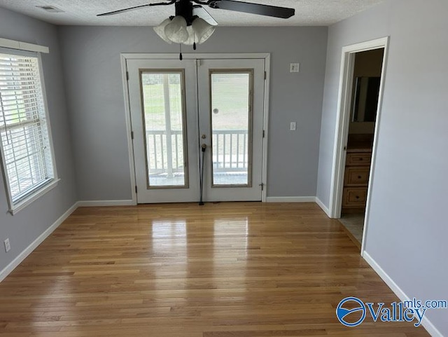 entryway featuring a textured ceiling, french doors, and a healthy amount of sunlight