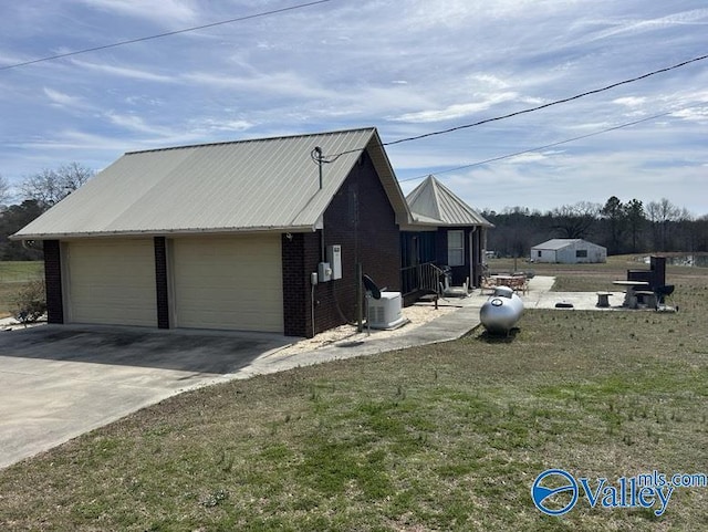 view of side of property with an outdoor structure, a garage, and a lawn