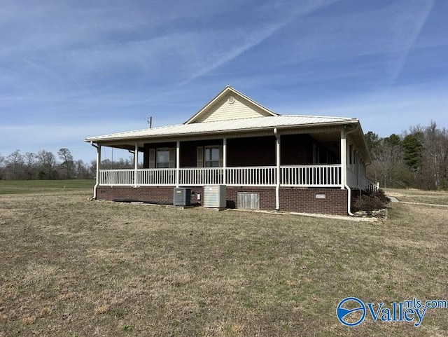 farmhouse with a front lawn and central AC unit