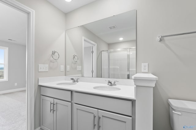 bathroom with vanity, toilet, and a shower with shower door