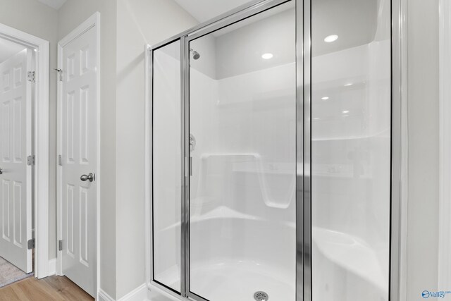 bathroom with wood-type flooring and walk in shower