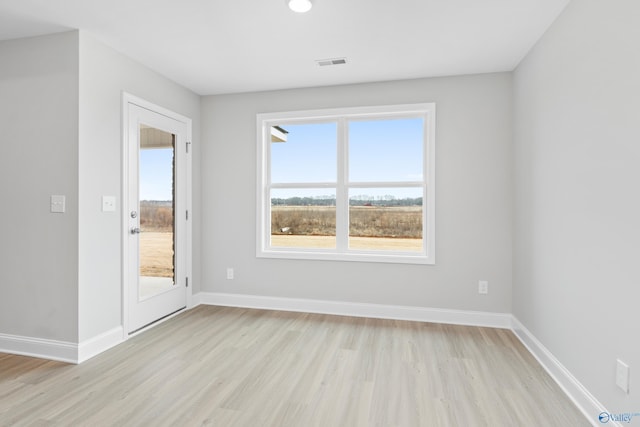 empty room featuring plenty of natural light and light hardwood / wood-style flooring