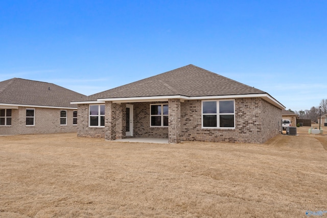 rear view of property with a yard, a patio area, and central air condition unit