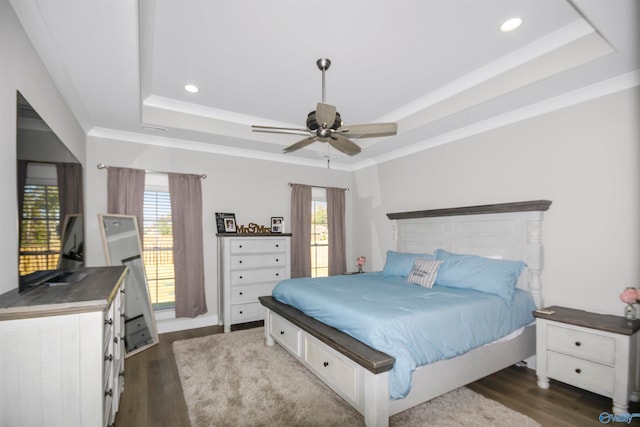 bedroom featuring ornamental molding, a tray ceiling, dark hardwood / wood-style floors, and ceiling fan