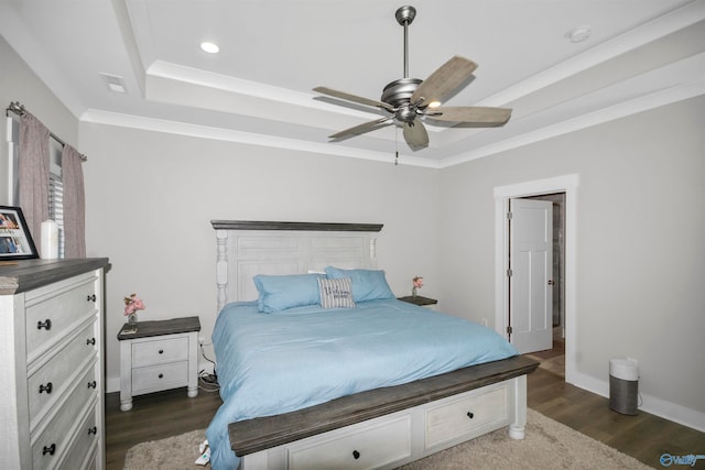 bedroom with dark wood-type flooring, a raised ceiling, and ceiling fan