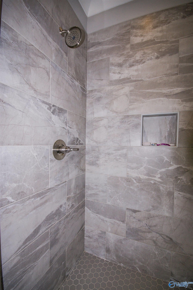 bathroom with tile patterned floors and a tile shower