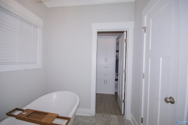 bathroom with a tub to relax in and hardwood / wood-style floors