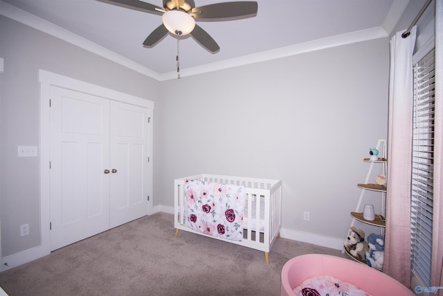 carpeted bedroom featuring crown molding, a nursery area, and ceiling fan