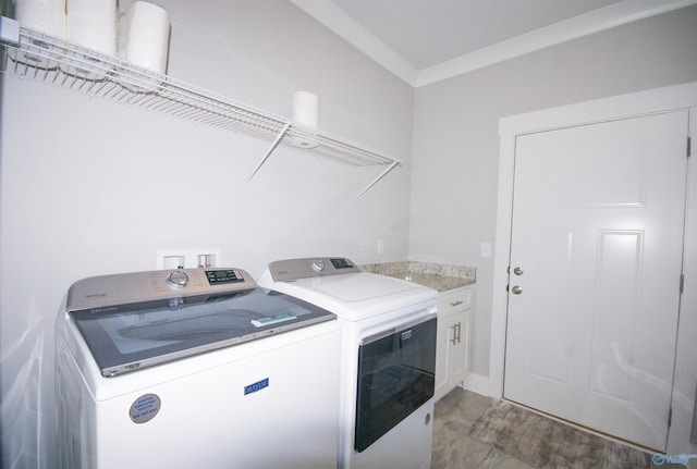 laundry area featuring ornamental molding, cabinets, and washing machine and clothes dryer