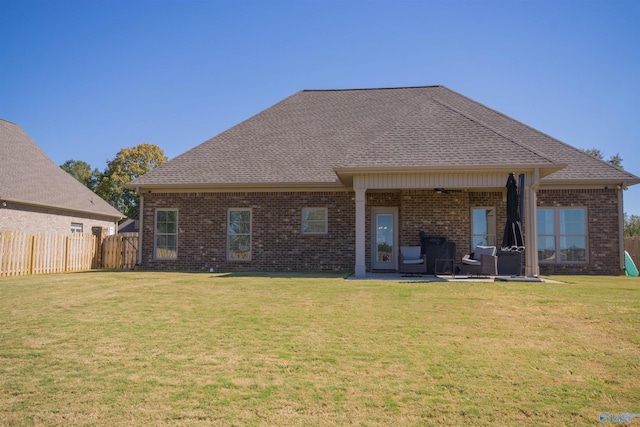 back of property with a patio and a yard