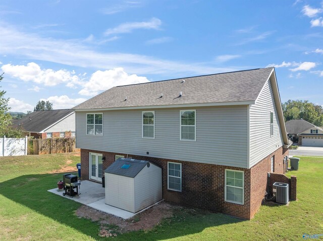 rear view of property featuring a patio area, central AC, and a lawn