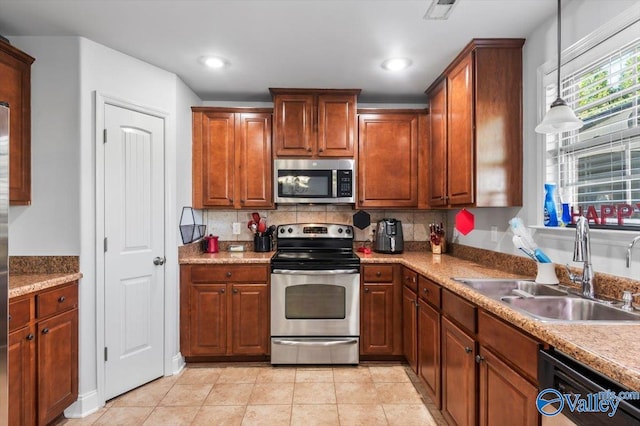 kitchen featuring backsplash, stainless steel appliances, sink, and hanging light fixtures