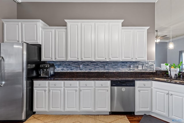 kitchen featuring ornamental molding, decorative backsplash, a sink, white cabinets, and appliances with stainless steel finishes