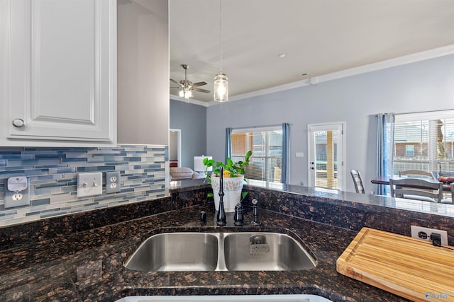 kitchen featuring tasteful backsplash, ornamental molding, a ceiling fan, and white cabinetry