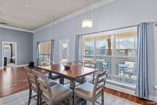 dining room featuring crown molding, baseboards, and wood finished floors