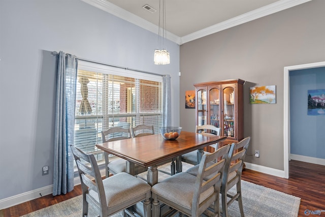 dining room featuring visible vents, crown molding, baseboards, and wood finished floors