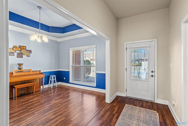 entryway featuring a wealth of natural light, a tray ceiling, wood finished floors, and a chandelier