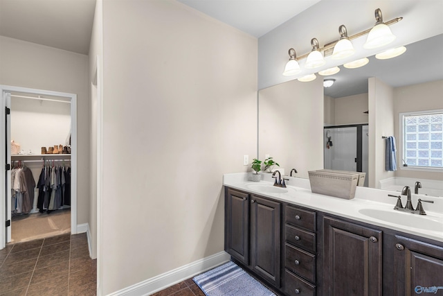 bathroom featuring a sink, a stall shower, and double vanity