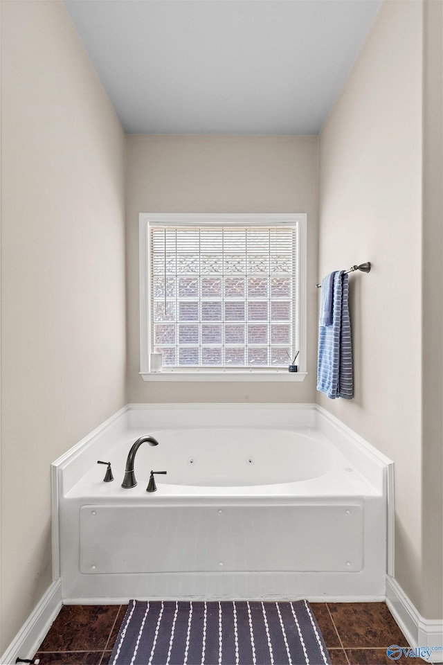 bathroom with tile patterned floors, baseboards, and a whirlpool tub