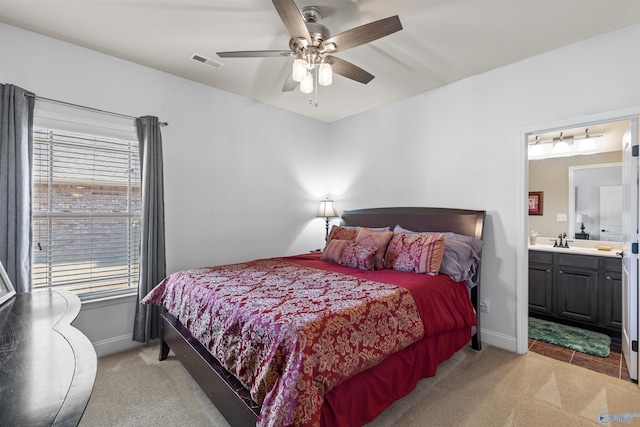 bedroom featuring baseboards, light colored carpet, visible vents, and a sink