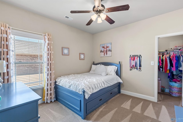 bedroom with a spacious closet, visible vents, a closet, and light carpet