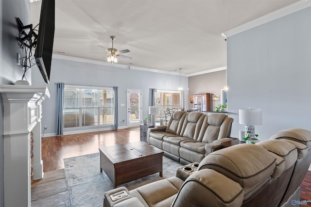 living room featuring wood finished floors, a fireplace, crown molding, baseboards, and ceiling fan