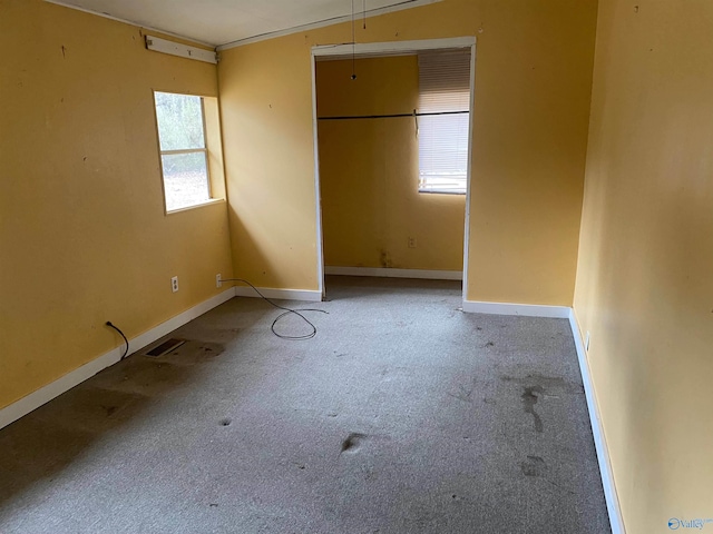 unfurnished bedroom featuring a closet, light colored carpet, and baseboards