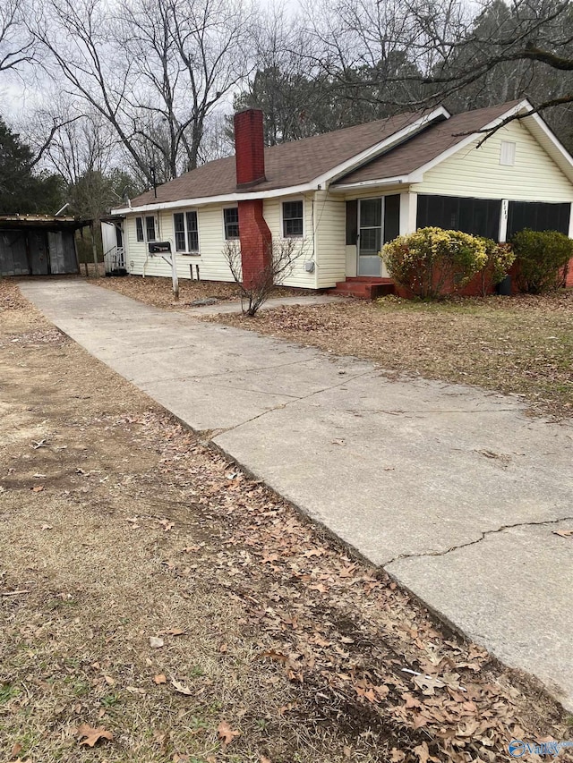 view of front of home with a chimney and concrete driveway