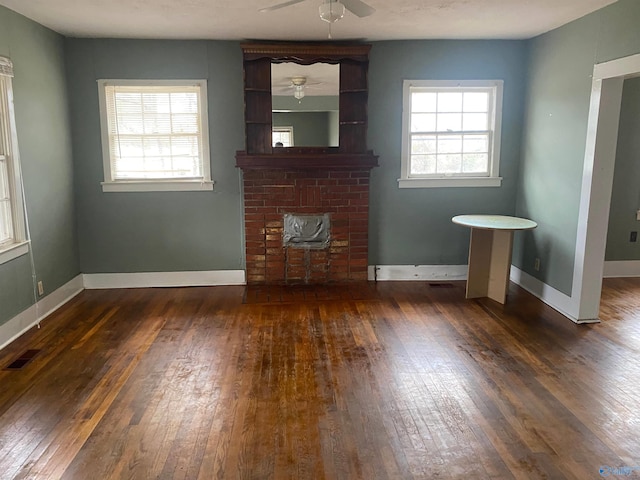 unfurnished living room featuring plenty of natural light, visible vents, and dark wood finished floors