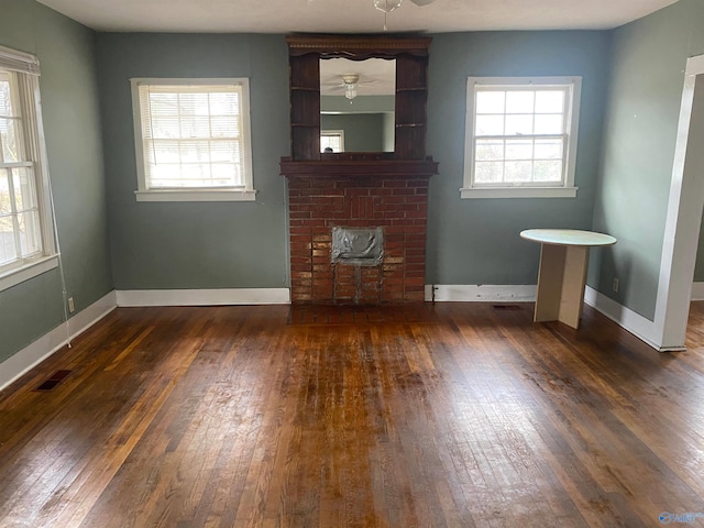 unfurnished living room featuring dark wood-style floors, visible vents, ceiling fan, and baseboards