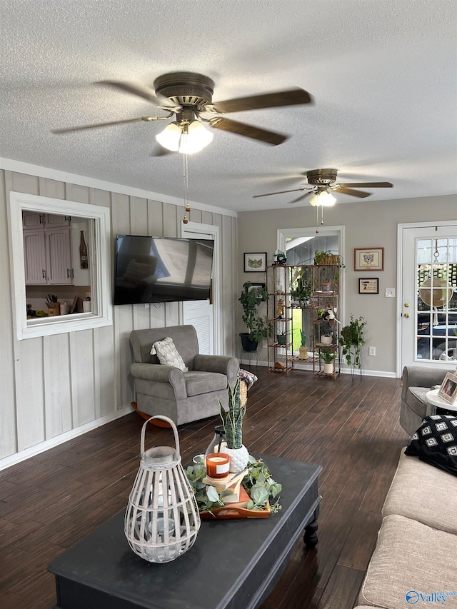 living room with ceiling fan, wood-type flooring, and a textured ceiling