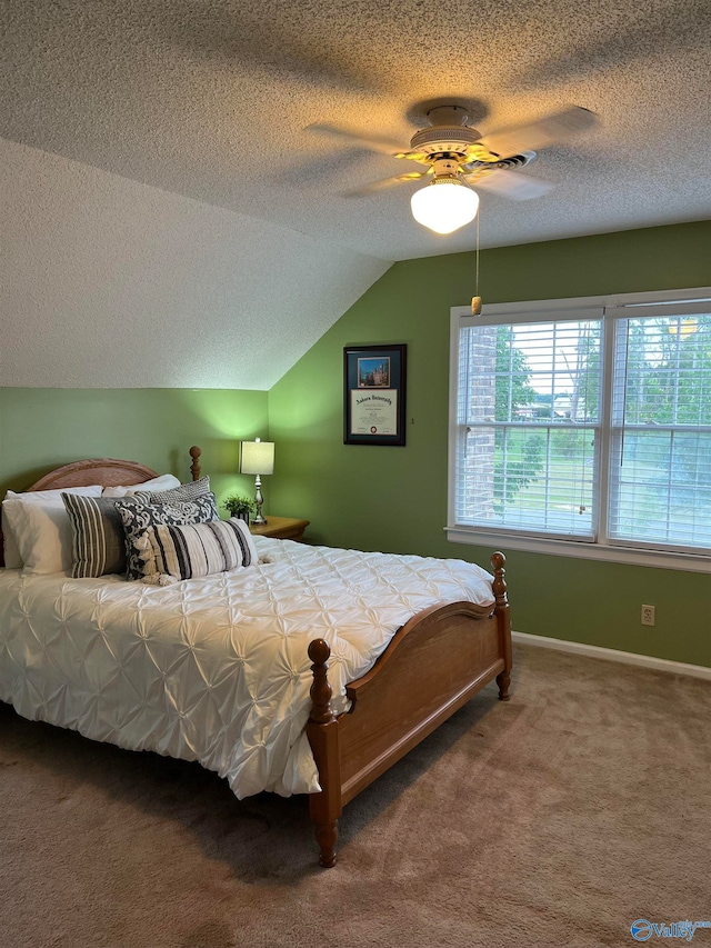 bedroom with ceiling fan, carpet flooring, a textured ceiling, and lofted ceiling