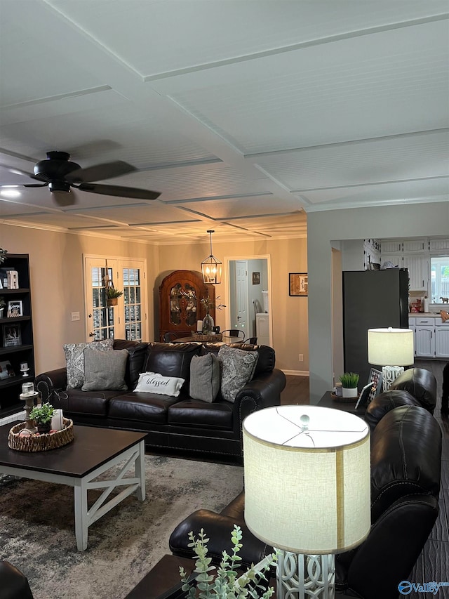 living room featuring ornamental molding and ceiling fan with notable chandelier