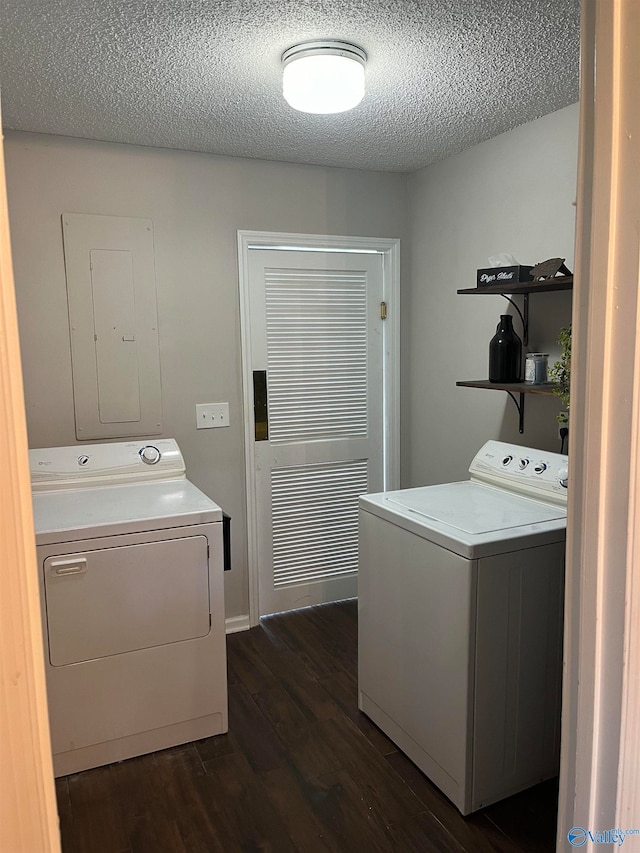 laundry room featuring separate washer and dryer, dark wood-type flooring, a textured ceiling, and electric panel