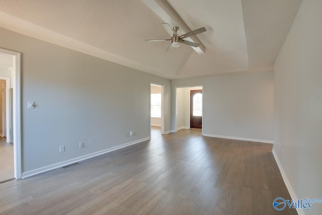 unfurnished room with a textured ceiling, ceiling fan, hardwood / wood-style floors, and vaulted ceiling