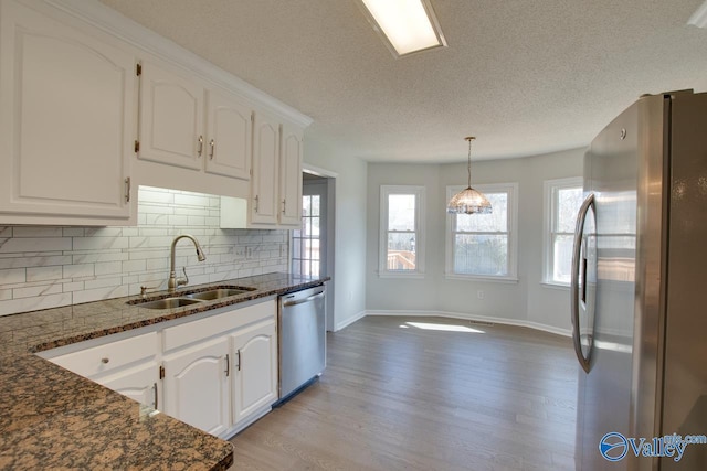 kitchen featuring white cabinets, appliances with stainless steel finishes, light wood-type flooring, and sink