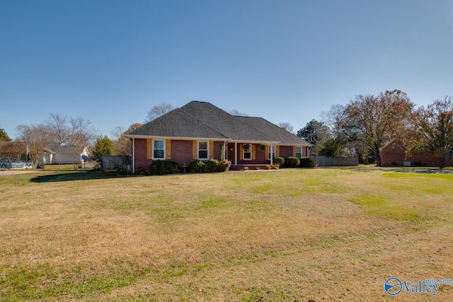 ranch-style house featuring covered porch and a front yard