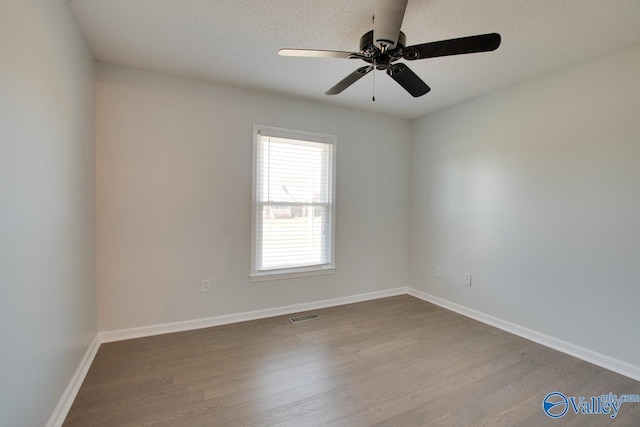 empty room featuring ceiling fan, light wood-type flooring, and a textured ceiling