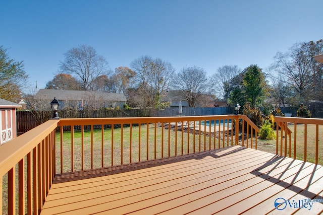 wooden deck featuring a yard and a pool