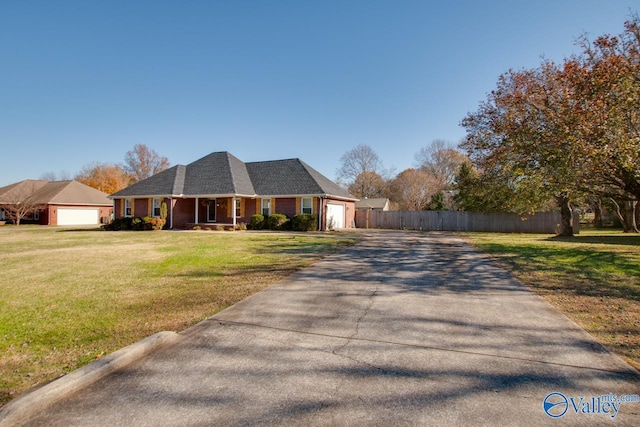 view of front of home with covered porch, a garage, and a front yard