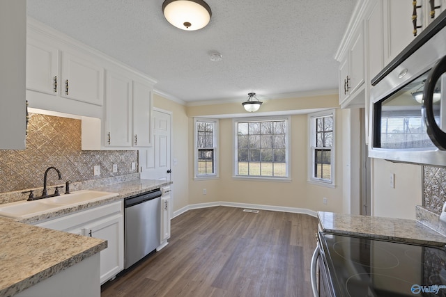 kitchen with tasteful backsplash, dark wood-style floors, white cabinets, stainless steel appliances, and a sink