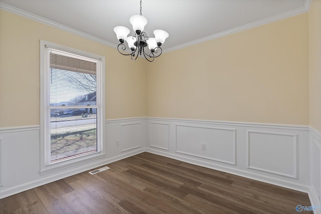 unfurnished room featuring visible vents, dark wood-style flooring, wainscoting, crown molding, and a notable chandelier