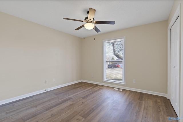 unfurnished bedroom featuring a closet, visible vents, baseboards, and wood finished floors