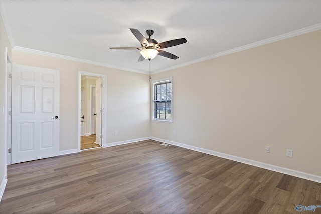 empty room with baseboards, dark wood-type flooring, ceiling fan, and crown molding