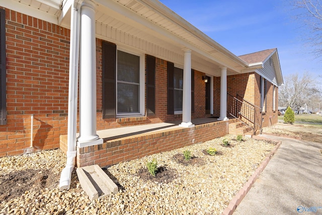 view of home's exterior with brick siding and a porch