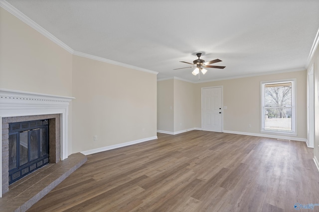 unfurnished living room featuring baseboards, ceiling fan, ornamental molding, a fireplace, and wood finished floors